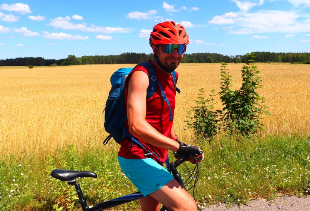 Uśmiechnięty rowerzysta, trasa rowerowa na Mazurach, słoneczny dzień