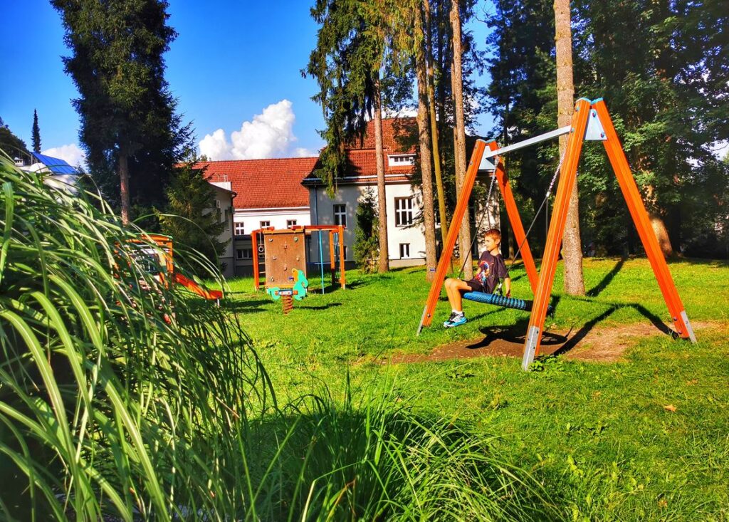 Dziecko na huśtawce, Bystra plac zabaw, zabytkowy park w Bystrej