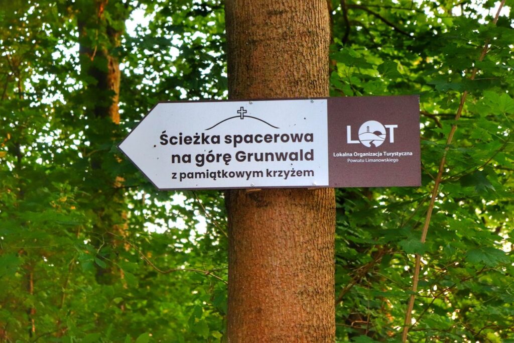 Drogowskaz, ścieżka spacerowa na Górę Grunwald z pamiątkowym krzyżem