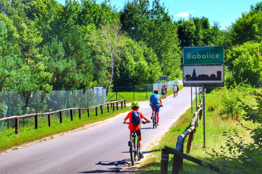 Rowerzyści - dziecko z tatą, znak - Bobolice, droga