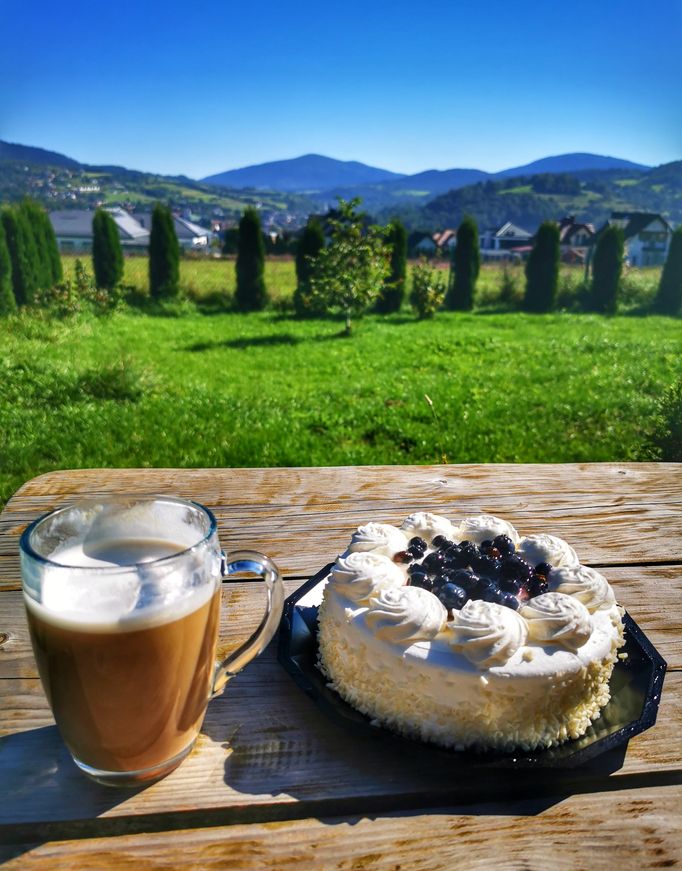 Tort, kubek z kawą, w tle krajobraz górski, Mszana Dolna