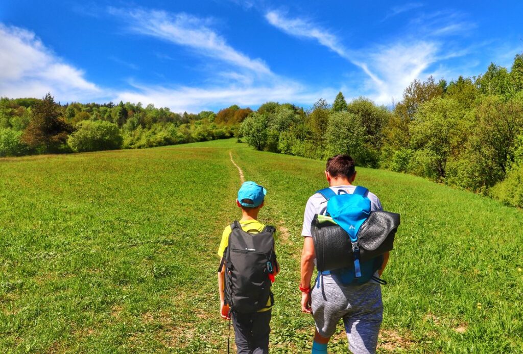 Turyści, dziecko z tatą, wakacyjne popołudnie, piękna polana w Beskidzie Niskim 