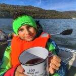 Uśmiechnięte dziecko na pontonie, kubek z herbatą, Jezioro Międzybrodzkie jesienią