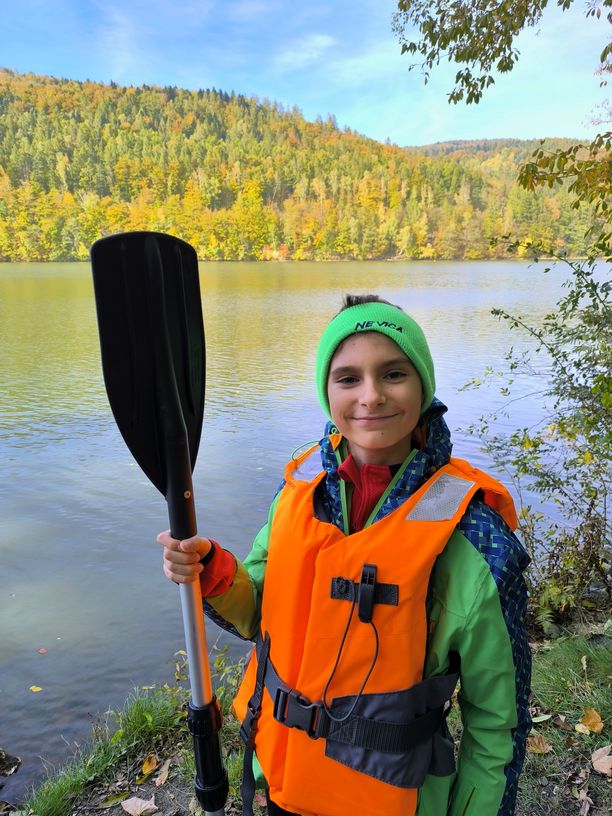 Uśmiechnięte dziecko nad jeziorem, wiosło