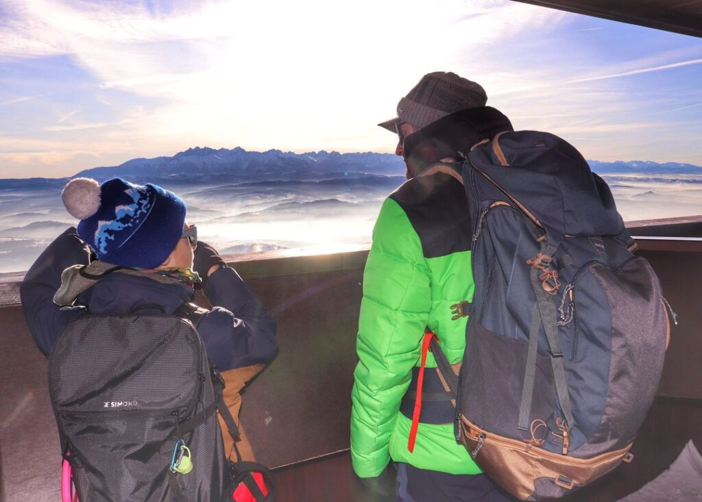 Turysta z dzieckiem na wieży widokowej na Lubaniu w Gorcach, widok na Tatry