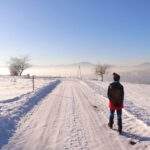Dziecko, szeroka i zaśnieżona droga w Łękawicy, szczyt Czoh w Beskidzie Małym