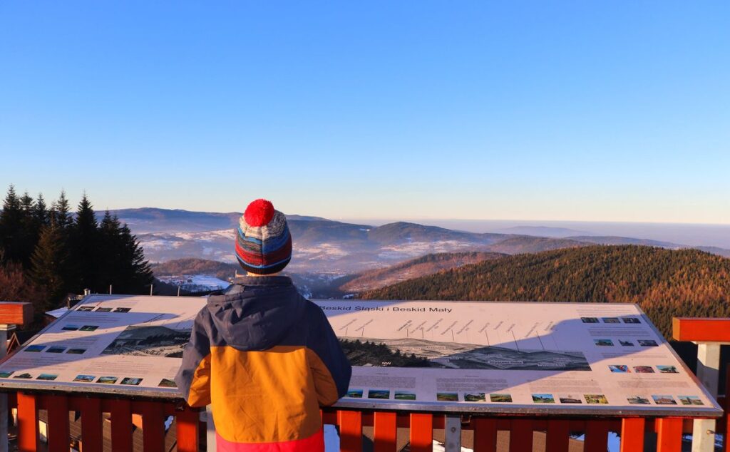 Dziecko, tablica z opisaną panoramą, widok na Beskid Śląski i Beskid Mały, Wieża widokowa w Stryszawie, Beskidzki Raj, niebieskie niebo