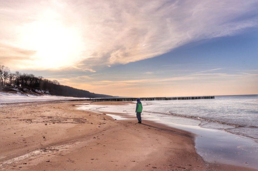 Dziecko na plaży w Trzęsaczu o zachodzie słońca