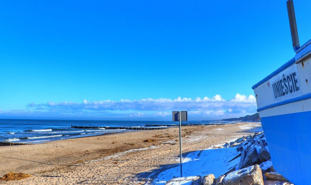 Kuter rybacki, widok na plażę w Unieściu, błękitne niebo 