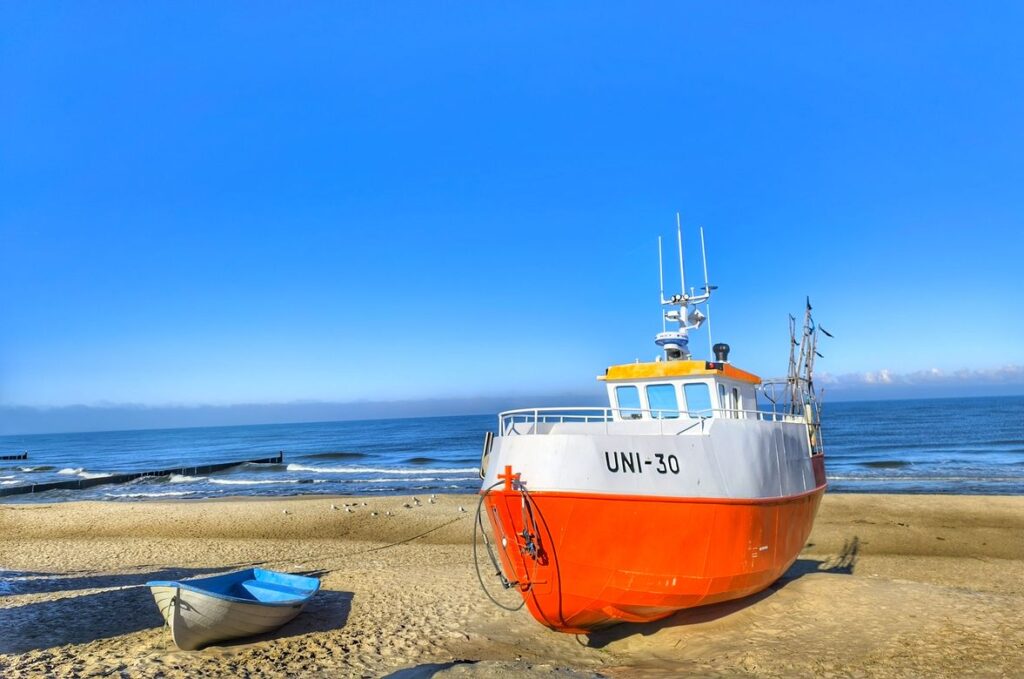 Plaża w Unieściu, kuter rybacki, niebieskie niebo