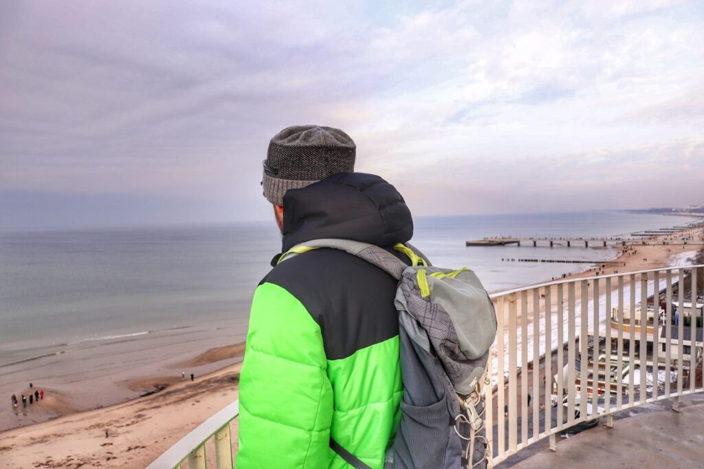 Turysta na Latarni w Kołobrzegu, widok na plażę i Bałtyk