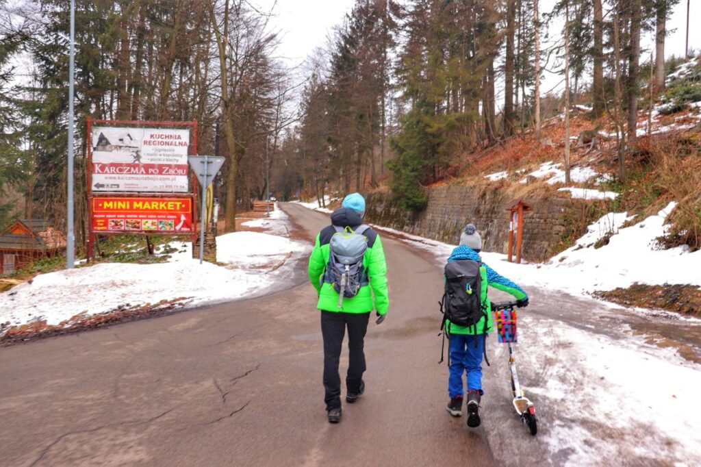 Turysta z dzieckiem wchodzący na Beskidzką Ścieżkę Planetarną w Istebnej