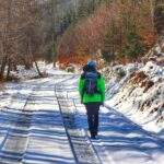 Turysta w Rycerce Górnej, szeroka leśna droga, zima