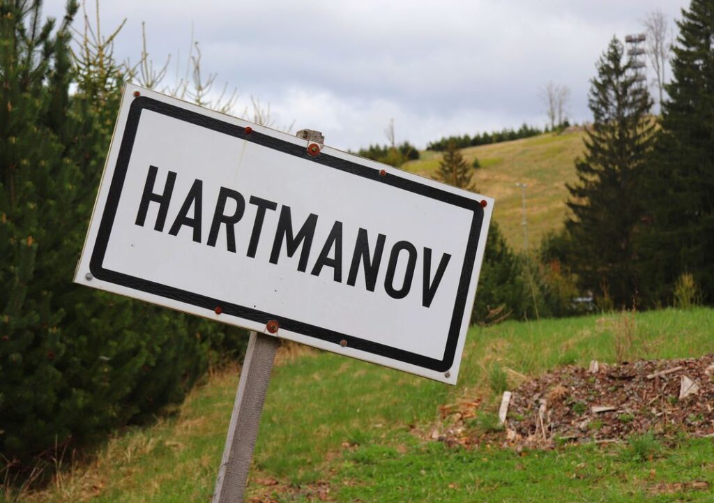 Biała tabliczka z czarnym napisem HARTMANOV, zielony szlak - Oleśnica, Czechy