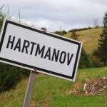 Biała tabliczka z czarnym napisem HARTMANOV, zielony szlak -Olesznica,Czechy