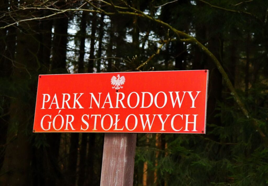 Czerwona tabliczka z białym napisem - PARK NARODOWY GÓR STOŁOWYCH