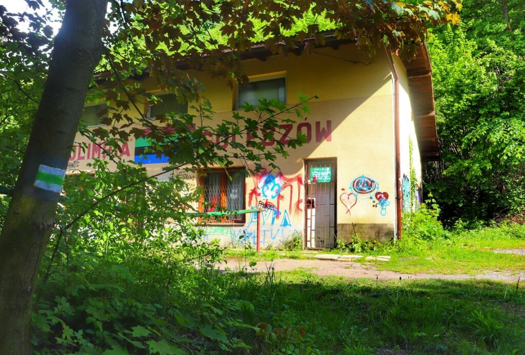 Oznaczenie zielonego szlaku na drzewie, budynek przy skoczni narciarskiej w Goleszowie
