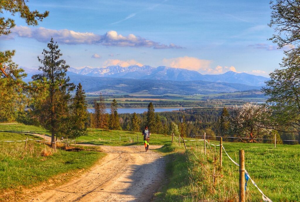 Turysta, zapierający dech widok na Jezioro Orawskie i Tatry, wiosna w Lipnicy Wielkiej, Marysina Polana