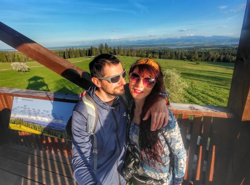Uśmiechnięta turystka z mężem na wieży widokowej. Marysina Polana - Lipnica Wielka, w tle widok na Tatry