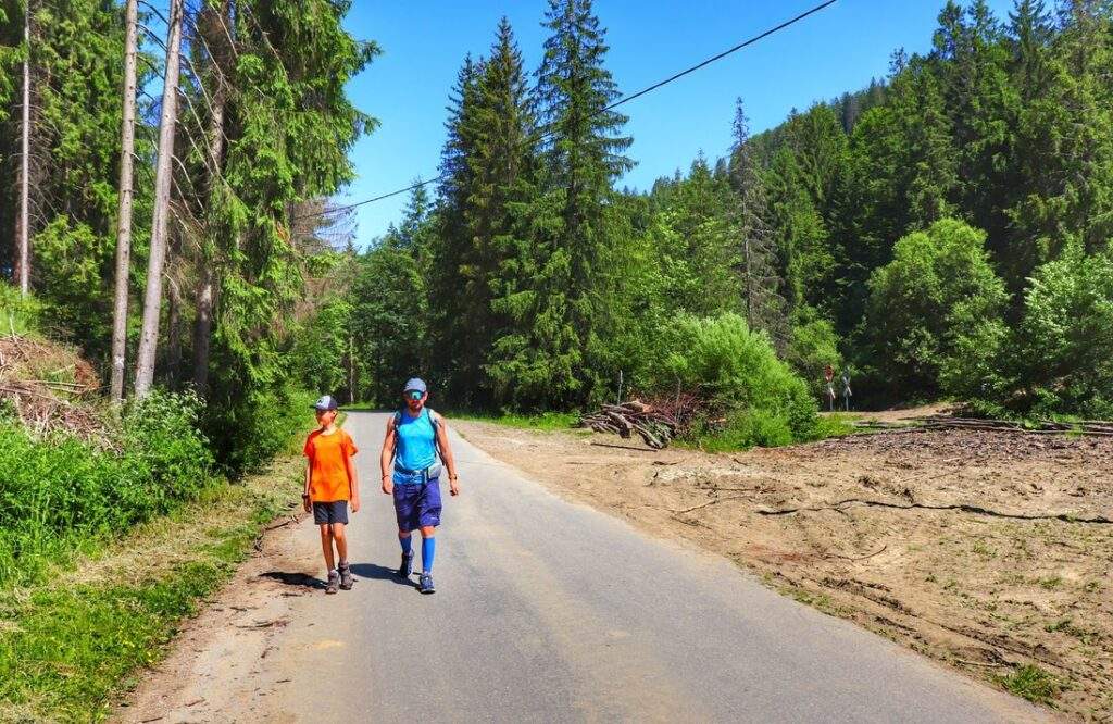 Nová Bystrica, turysta z dzieckiem, droga asfaltowa, słoneczny dzień