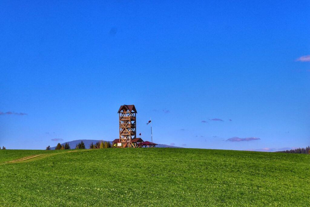 Zakamenne - drewniana wieża widkowa, polana, niebieskie niebo