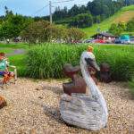 Dziecko siedzące na ławeczce, plac zabaw „Podróżujemy po Europie” w Bukovcu