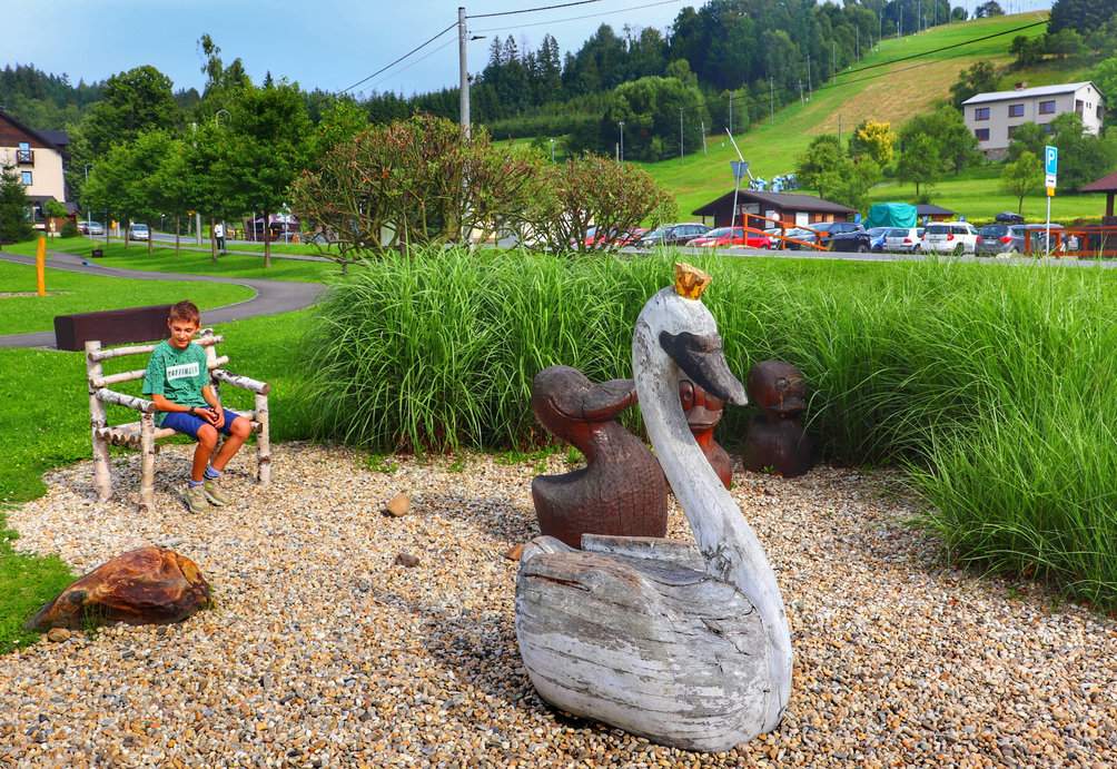 Dziecko siedzące na ławeczce, plac zabaw „Podróżujemy po Europie” w Bukovcu