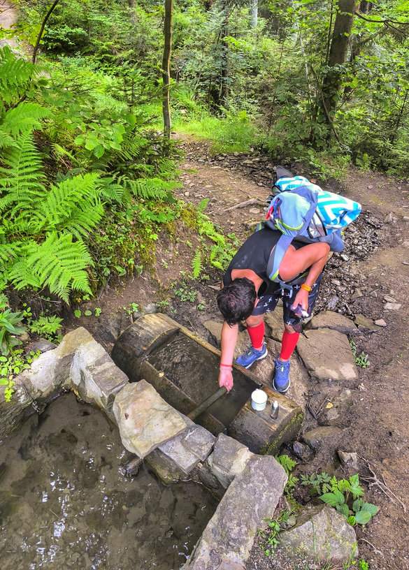 Oszczadnica na Słowacji, źródełko górskie na żółtym szlaku, turysta