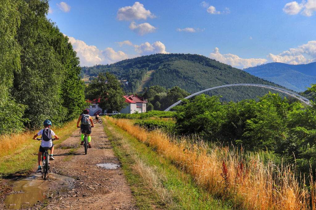 Rowerzyści, dziecko z tatą, ścieżka prowadząca wzdłu jeziora - Zbiornik Czaniecki, Porąbka