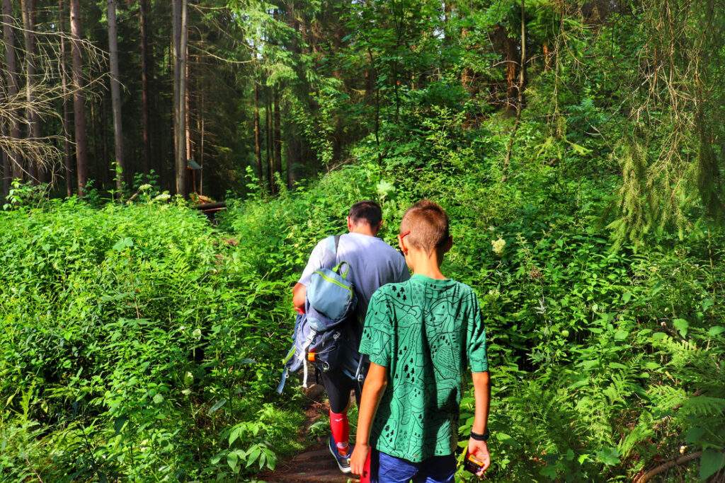Turysta z dzieckiem na ścieżce przyrodniczej - Rezerwat Przyrody Bukovec, Czechy