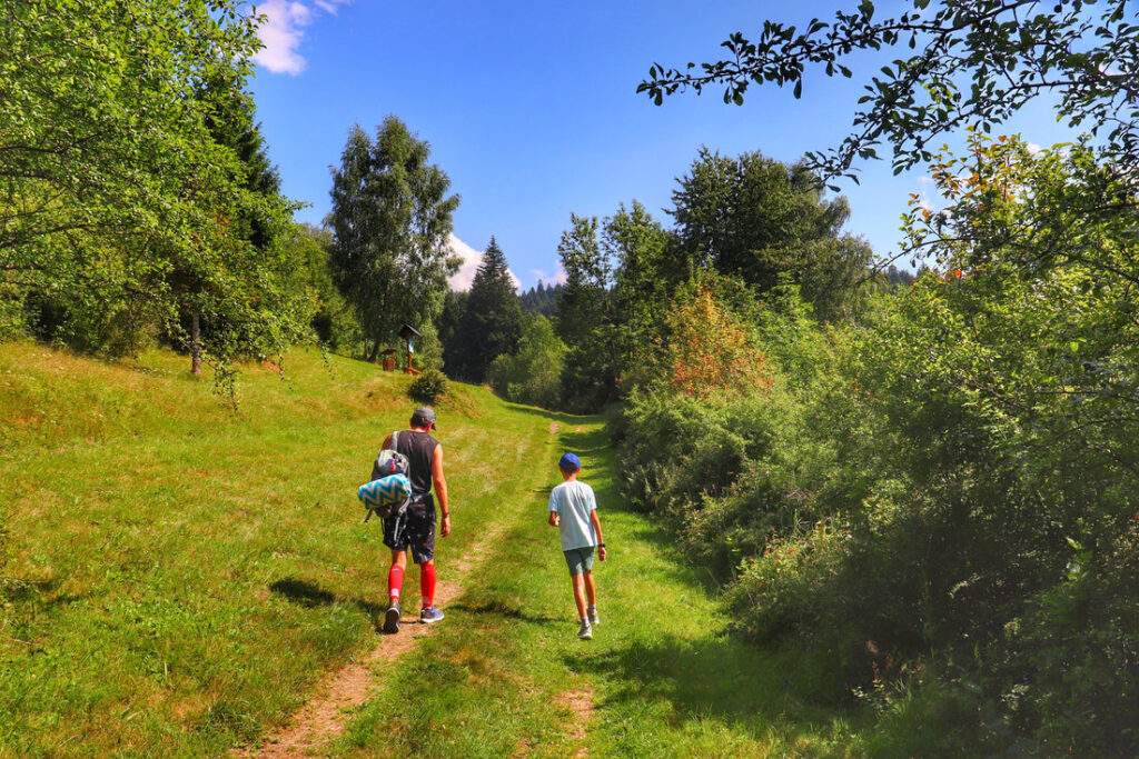 Turysta z dzieckiem na żółtym szlaku, Oszczadnica, ścieżka prowadząca w górę szlaku