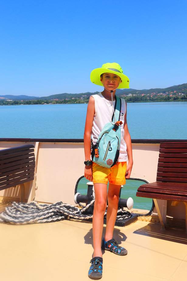 Uśmiechnięte dziecko na statku wycieczkowym, ławki, widok na Balaton, Keszthely 