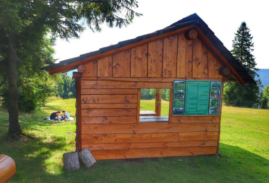 Wiata turystyczna przy wieży widokowej Surovina, Oszczadnica, w tle turysta z dzieckiem