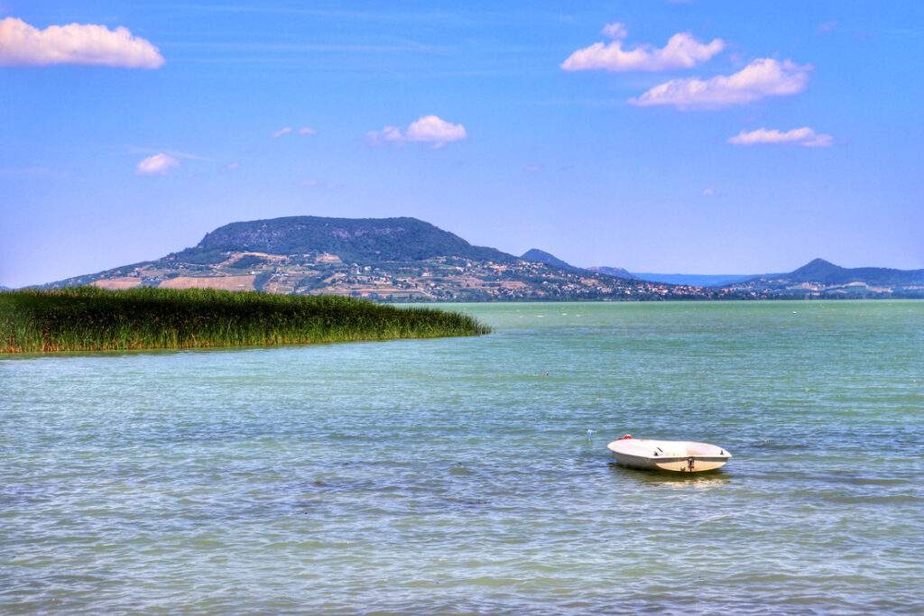 Widok na jezioro Balaton i wulkaniczne wzgórza, niebieskie niebo, plaża Csalogány w Balatonfenyves