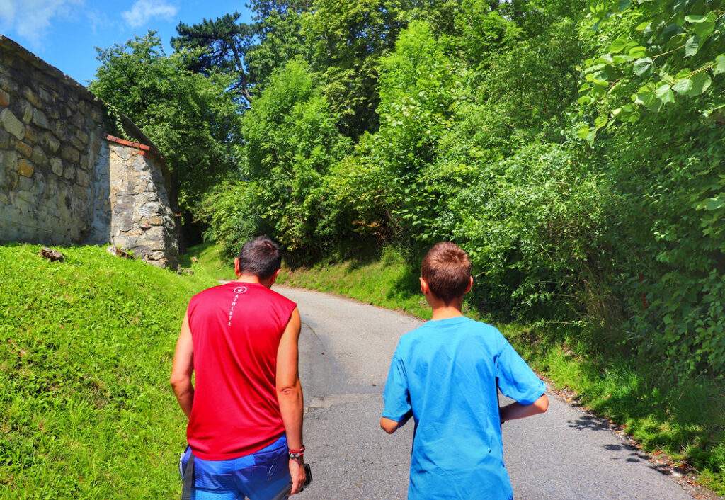 Dziecko z tatą na asfaltowej drodze wznoszącej się w górę w Starým Jičínie