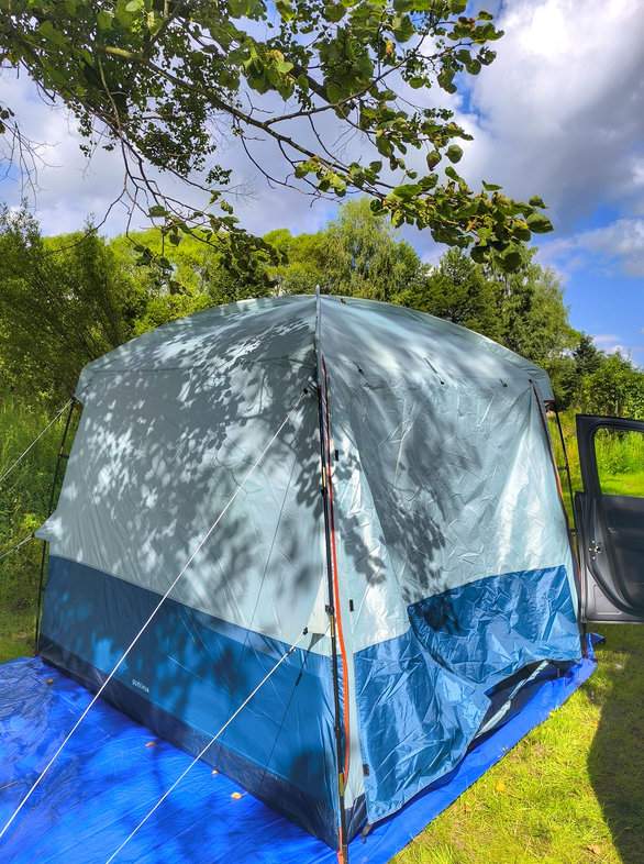 Namiot, zielona trawa, niebieskie niebo, białe chmury