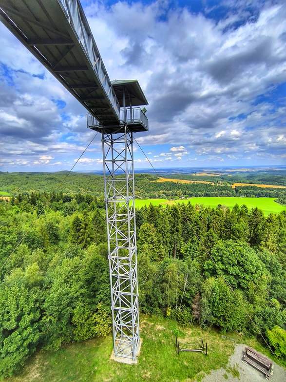Widok na kładkę i górny taras widokowy wieży na Granicznym Wierchu w Czechach, lato, soczysta zieleń, niebo niebieskie z churami