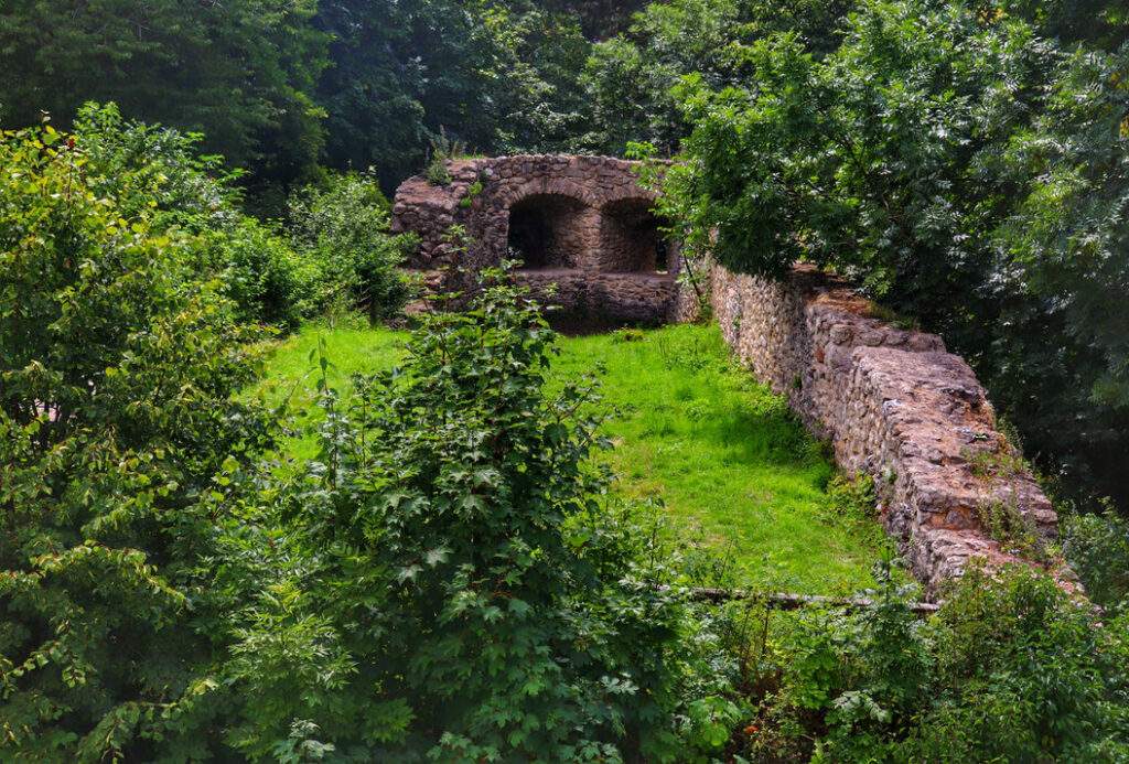 Widok na mury zamku w Starým Jičínie, które wznoszą się malowniczo między drzewami