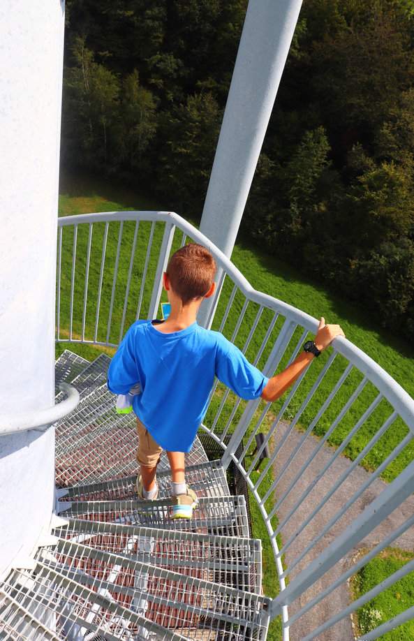 Dziecko schodzące z wieży widokowej Okrouhlá, wąskie, kręta i kratkowane schody
