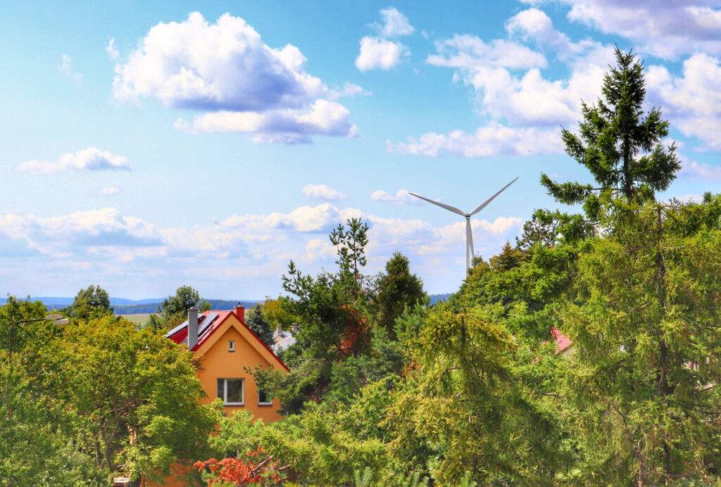 Widok z wieży widokowej Veselská na dom i wiatrak, niebieskie niebo z białymi obłokami - miejscowość Odry, Czechy.