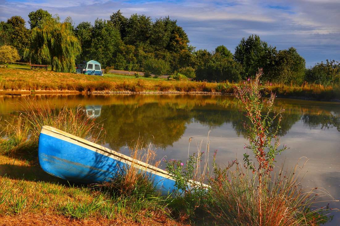 Staw Hetlik w pobliżu Skuteč - łódka zacumowana przy brzegu, namiot w oddali i piękny, słoneczny dzień