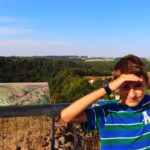 Uśmiechnięte dziecko na wieży widokowej Milada - ruiny zamku Lichnice w Górach Żelaznych, Czechy, słoneczne popołudnie