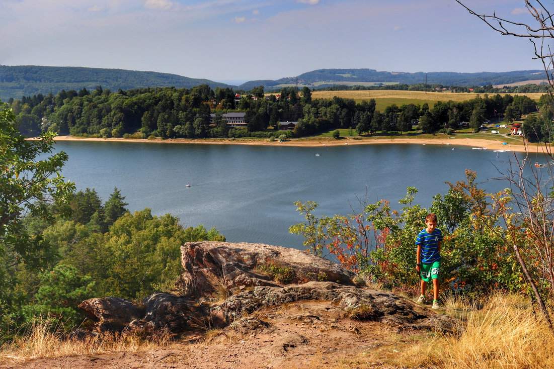Dziecko na tle zbiornika Seč - widok ze skalnego punktu widokowego Mały Oheb w Górach Żelaznych