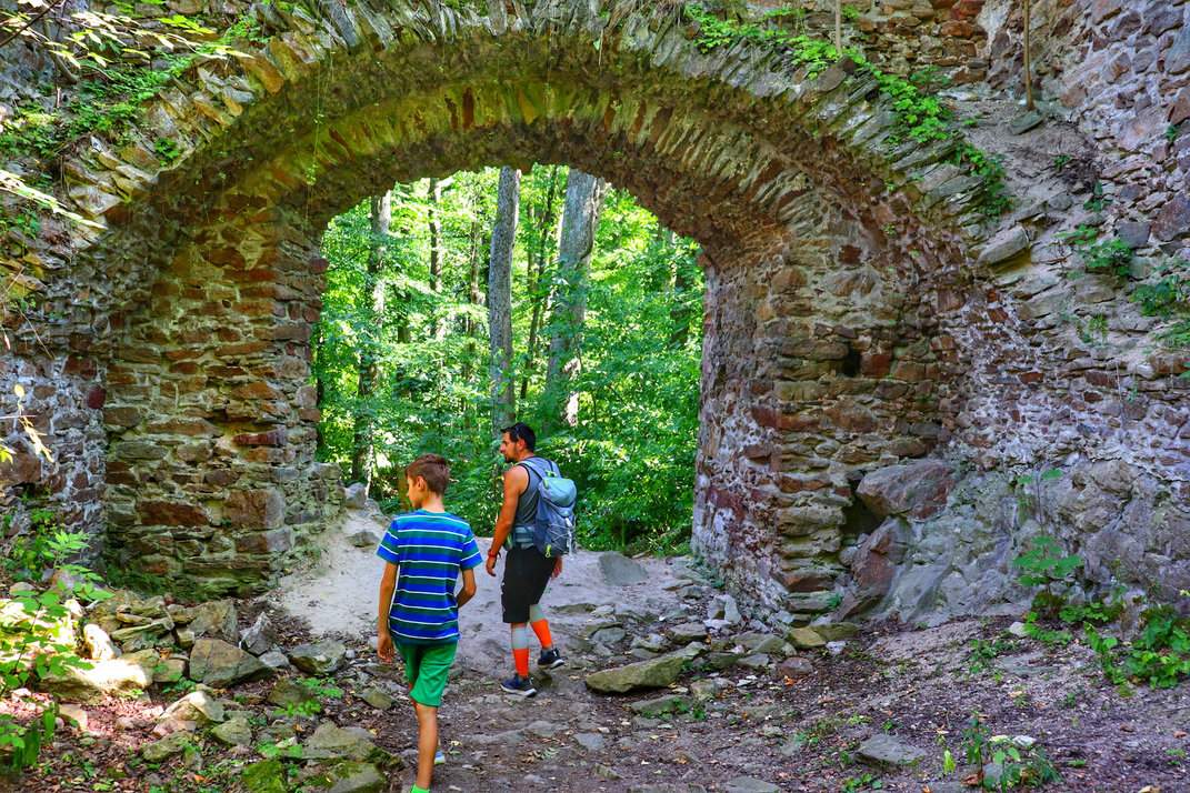 Turysta z dzieckiem zwiedzający ruiny zamku Oheb w Górach Żelaznych