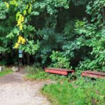 Miejsce wejścia do Narodowego Rezerwatu Przyrody Hůrka u Hranic w Czechach, czerwony szlak prowadzący do przepaści Hranická propast, drewniane ławki