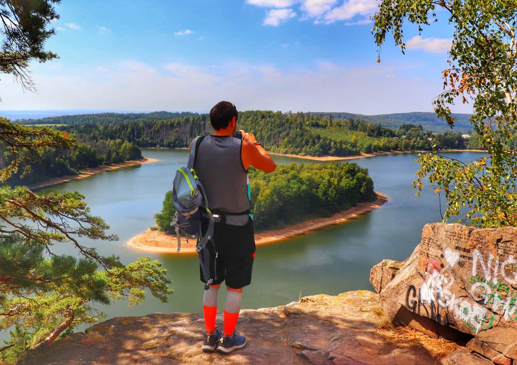 Turysta na skalnym punkcie widokowym Oheb - widok na zbiornik Seč