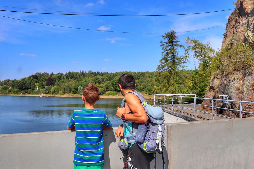 Turysta z dzieckiem podziwiający widok na zbiornik Seč w Czechach w piękne, letnie popołudnie pod błękitnym niebem