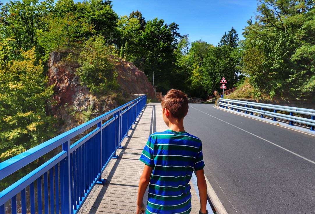 Dziecko idące chodnikiem po moście w okolicach zapory i zbiornika Seč w Górach Żelaznych