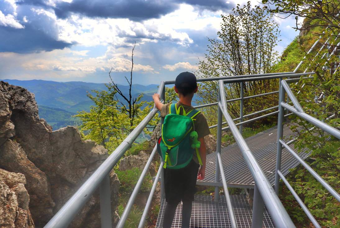 Dziecko idące po metalowej platformie na Trzech Koronach w Pieninach, w tle górski krajobraz