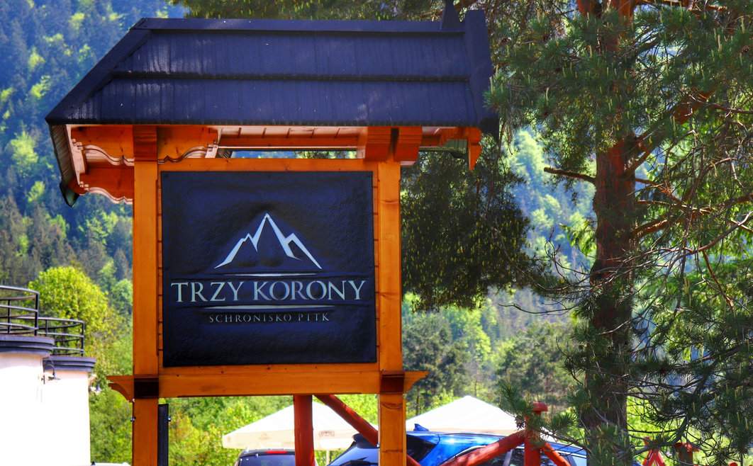 Tablica „Trzy Korony - Schronisko PTTK” tuż przy budynku schroniska